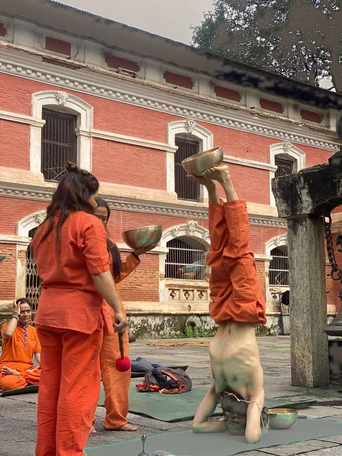 Yogi Ji with bronze singing bowls set out on the ground during a sound session at the temple.